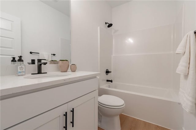 bathroom with toilet, shower / bathtub combination, wood finished floors, and vanity