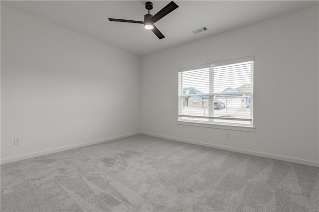 unfurnished room with light carpet, baseboards, visible vents, and ceiling fan