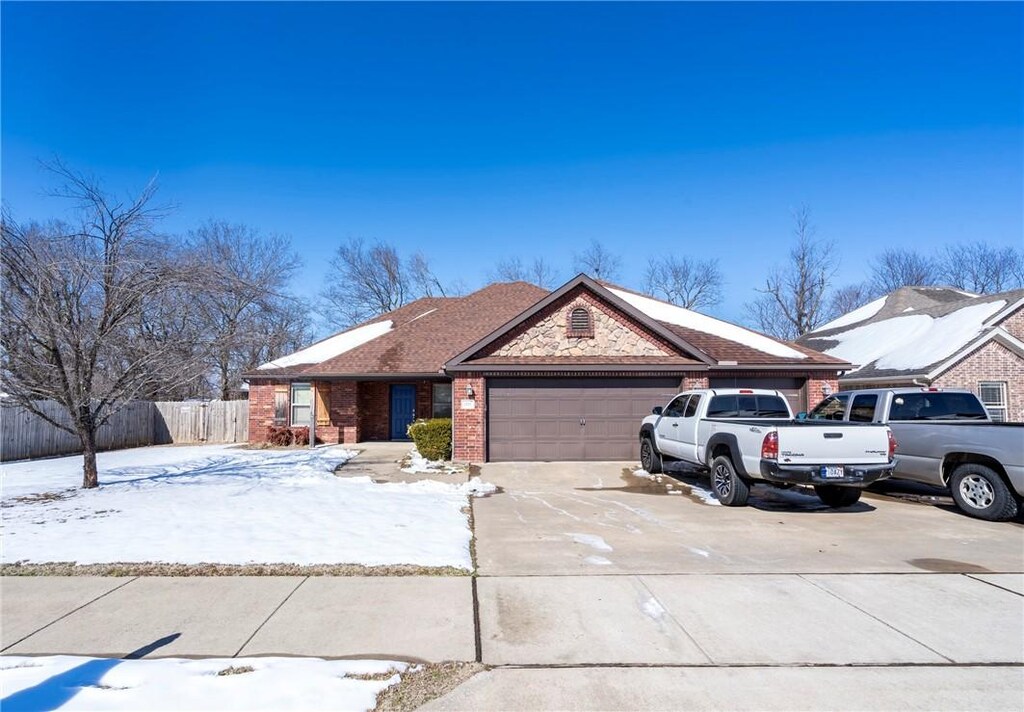 1701 Stratton Dr, Rogers, AR 72756 - view of front of home featuring a garage, brick siding, driveway, and fence