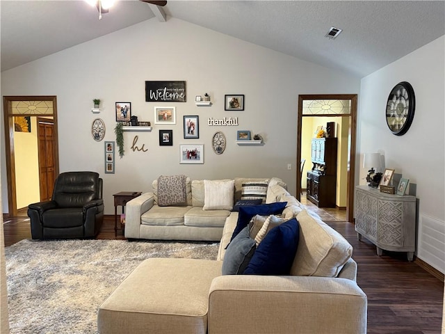 living room with vaulted ceiling with beams, dark wood-style floors, and visible vents