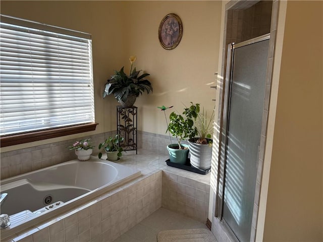 full bathroom featuring a tub with jets and a shower stall