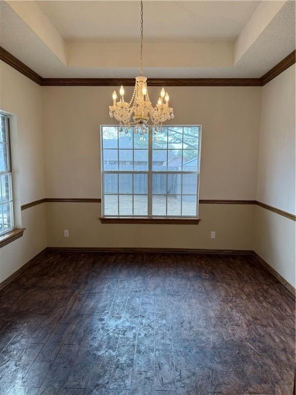 unfurnished room featuring crown molding, a raised ceiling, a wealth of natural light, and a notable chandelier