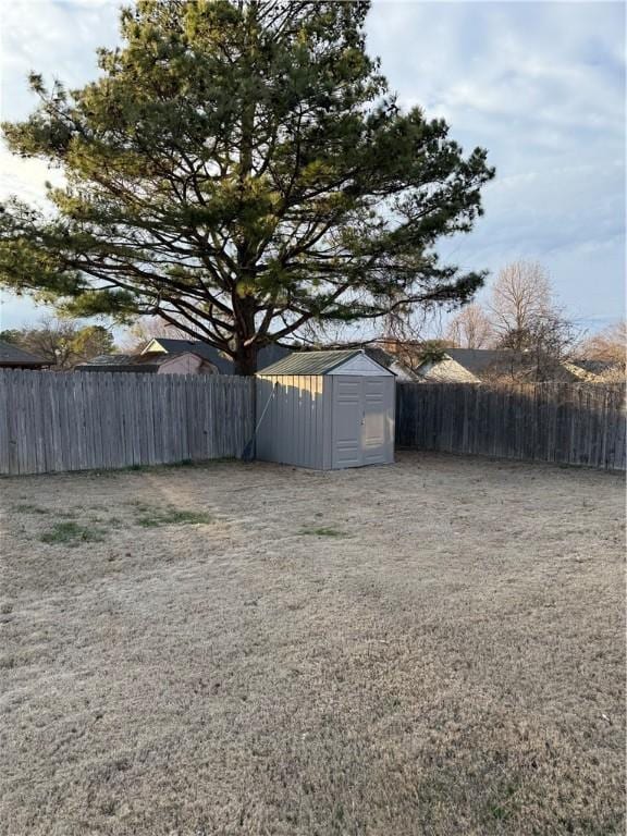 view of yard with fence, an outdoor structure, and a shed