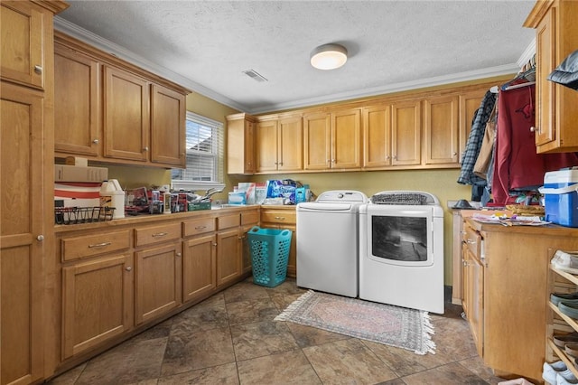 clothes washing area with cabinet space, visible vents, ornamental molding, washer and dryer, and a sink