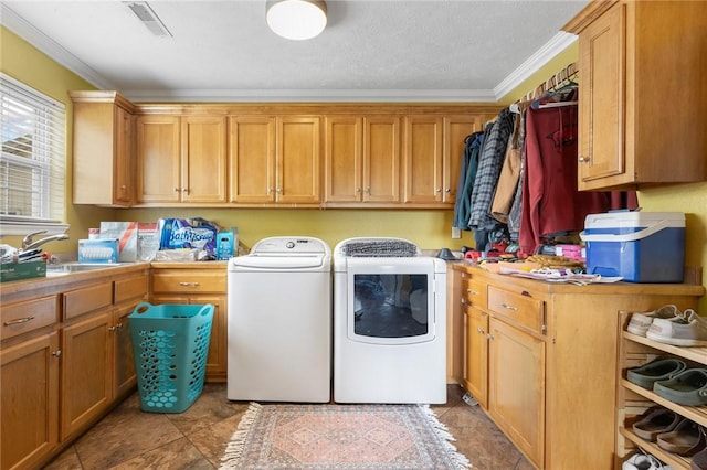 laundry area featuring ornamental molding, washer and dryer, cabinet space, and a sink