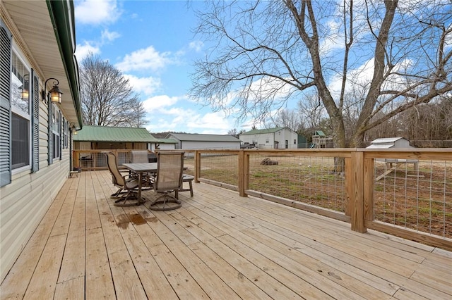 wooden terrace featuring a playground and outdoor dining space