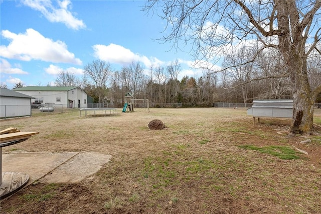 view of yard with a swimming pool, a trampoline, fence, and a playground