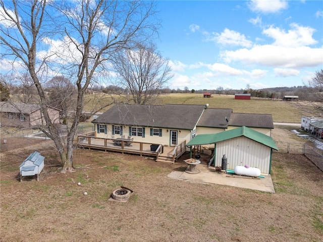 exterior space with a fire pit, a yard, a wooden deck, and fence