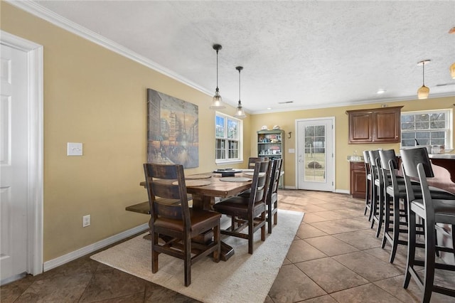 tiled dining area with a textured ceiling, ornamental molding, and a wealth of natural light