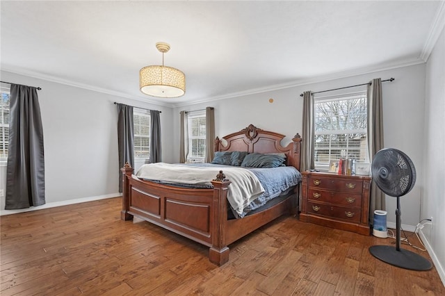 bedroom with dark wood-style floors, ornamental molding, multiple windows, and baseboards