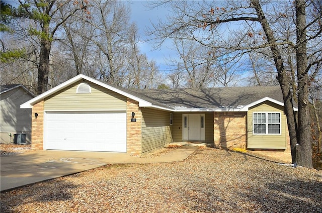 single story home featuring an attached garage, central air condition unit, driveway, and brick siding