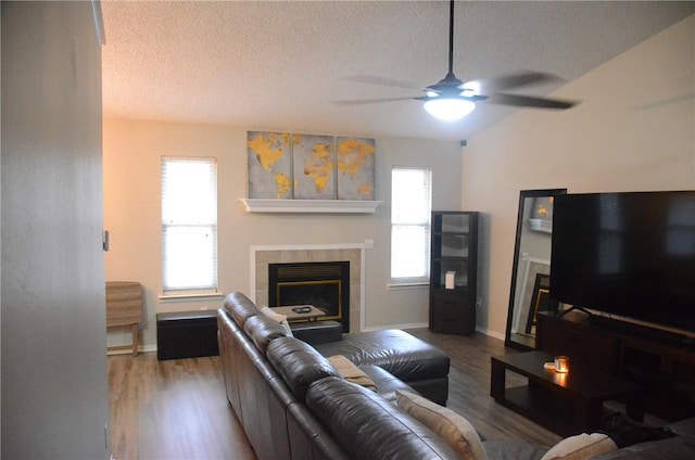 living room with a textured ceiling, a fireplace, and wood finished floors