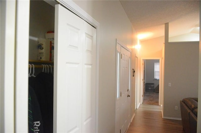 corridor featuring baseboards and wood finished floors