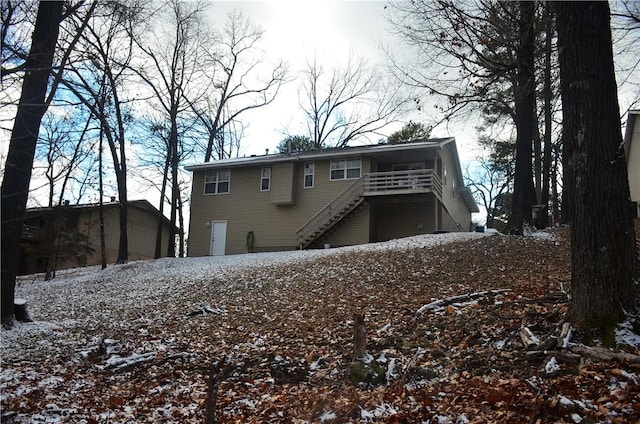 snow covered back of property with a balcony