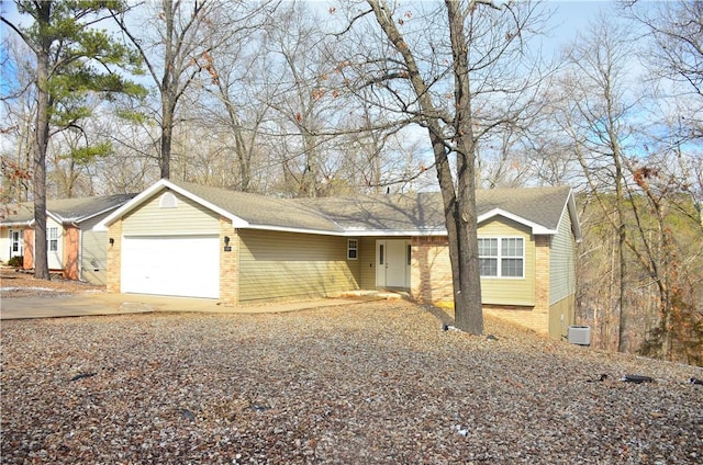 ranch-style home with a garage, driveway, and brick siding