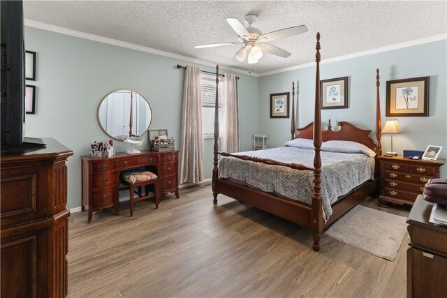 bedroom featuring crown molding, light wood-style flooring, a ceiling fan, and a textured ceiling