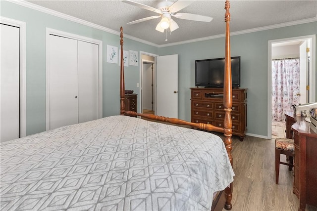 bedroom featuring two closets, ceiling fan, ornamental molding, and wood finished floors
