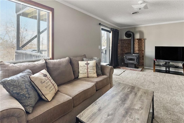 carpeted living area with a textured ceiling, a wood stove, baseboards, and ornamental molding