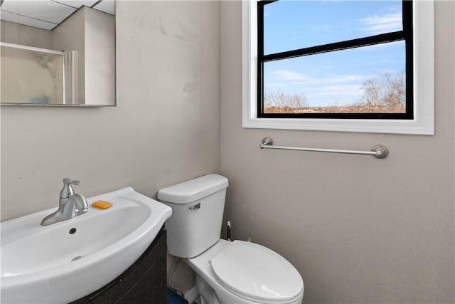 bathroom with an enclosed shower, toilet, and a sink