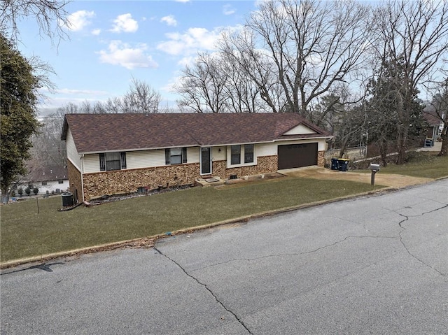 single story home with brick siding, driveway, an attached garage, and a front lawn