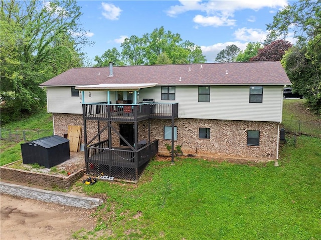 rear view of house with fence, central air condition unit, brick siding, a wooden deck, and a lawn