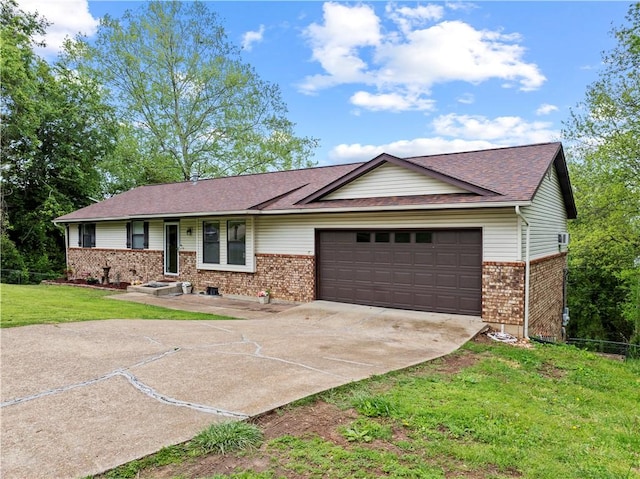 single story home featuring a garage, concrete driveway, a front yard, and brick siding