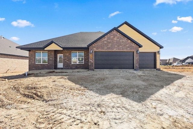 single story home featuring brick siding, roof with shingles, driveway, and an attached garage