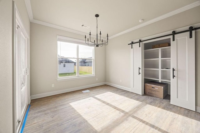 4767 Cowboy St, Springdale, AR 72762 - unfurnished dining area featuring a barn door, ornamental molding, a chandelier, wood finished floors, and baseboards