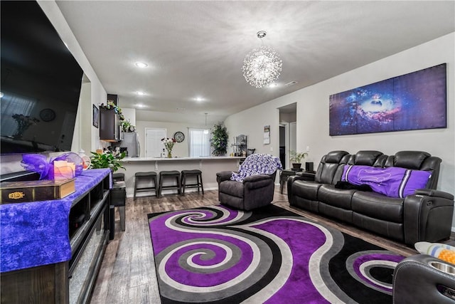 living area featuring a chandelier, wood finished floors, and recessed lighting