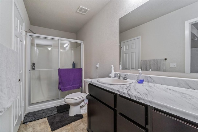 bathroom with toilet, a stall shower, visible vents, and vanity