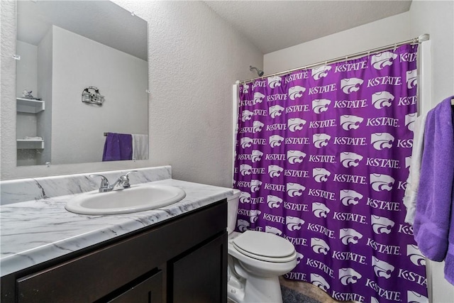 full bathroom featuring toilet, a textured wall, a shower with shower curtain, and vanity