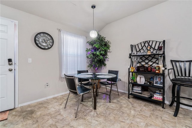 dining room featuring lofted ceiling and baseboards