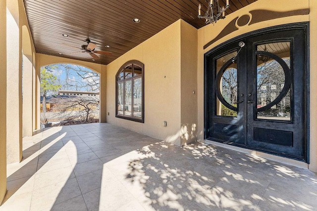 doorway to property with a patio, french doors, a ceiling fan, and stucco siding