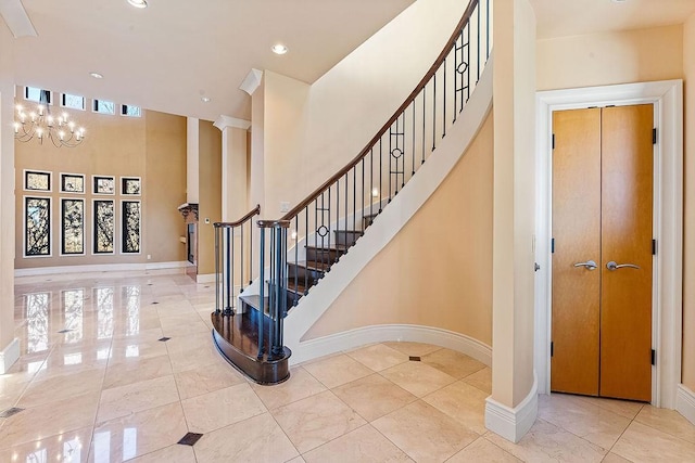 staircase with an inviting chandelier, baseboards, and recessed lighting