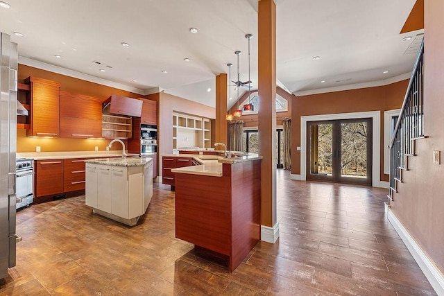 kitchen with light countertops, french doors, range, modern cabinets, and a center island with sink