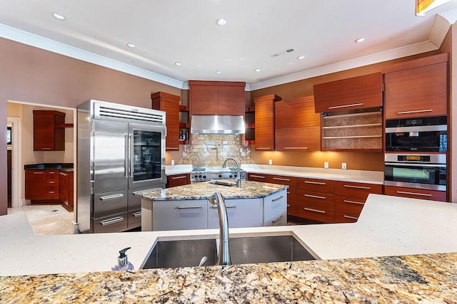 kitchen featuring a center island with sink, visible vents, a sink, ventilation hood, and modern cabinets