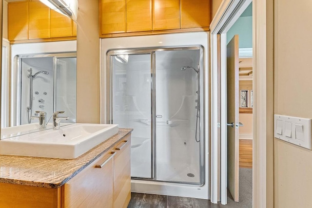 full bath with a shower stall, wood finished floors, and vanity