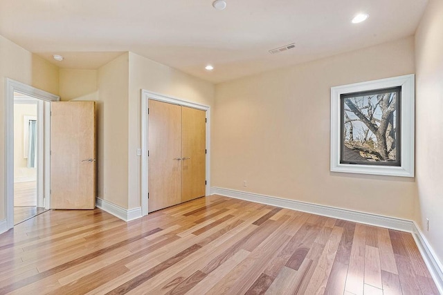 empty room with baseboards, recessed lighting, visible vents, and light wood-style floors