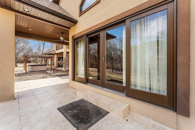 entrance to property with french doors, a patio, and ceiling fan