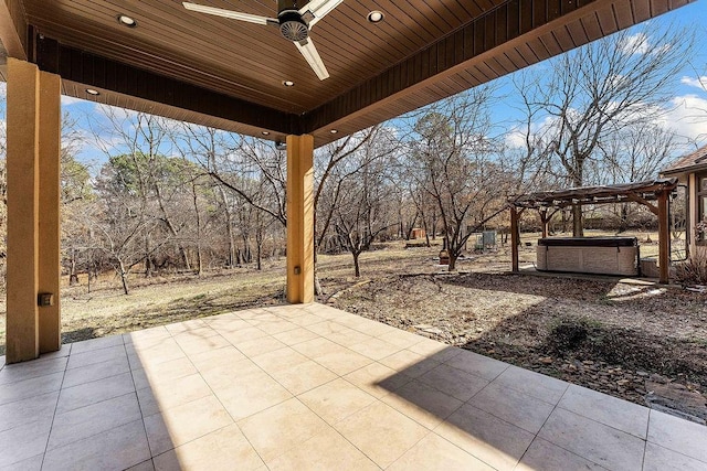 view of patio with a hot tub, ceiling fan, and a pergola