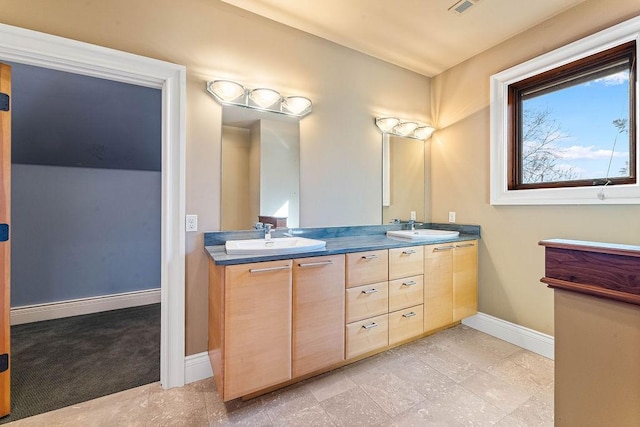 full bath with visible vents, a sink, baseboards, and double vanity