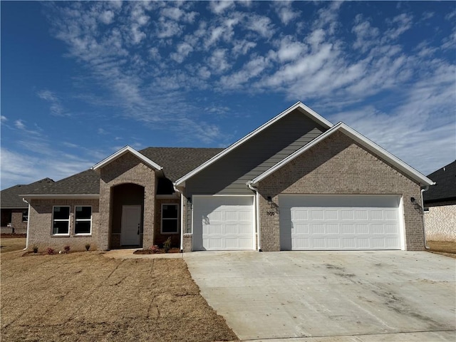 view of front of house with a garage, concrete driveway, and brick siding