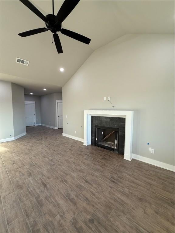 unfurnished living room featuring a fireplace, lofted ceiling, dark wood-type flooring, a ceiling fan, and baseboards