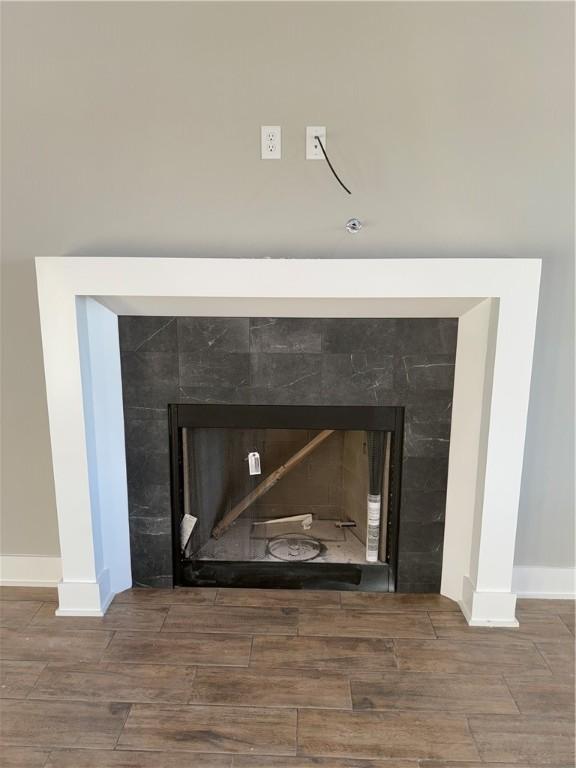 details featuring wood tiled floor, a fireplace, and baseboards