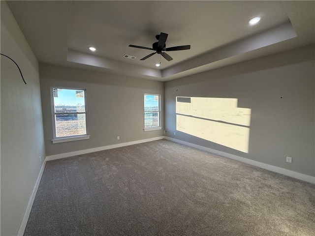 unfurnished room featuring baseboards, visible vents, and a raised ceiling