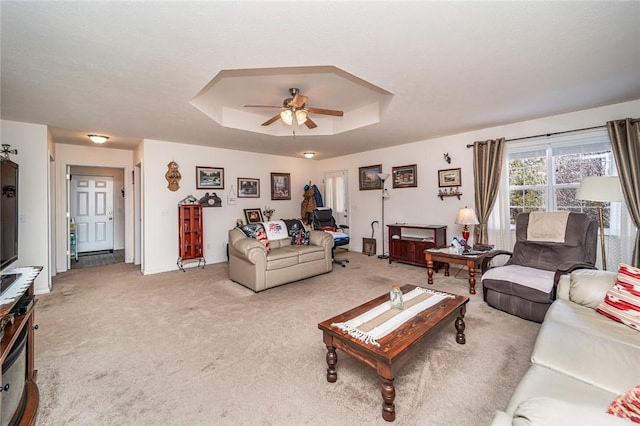 410 Paradise Heights Dr, Berryville, AR 72616 - living room featuring light carpet, baseboards, a tray ceiling, and a ceiling fan