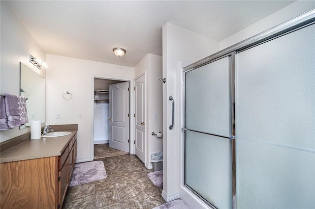 410 Paradise Heights Dr, Berryville, AR 72616 - bathroom with a stall shower, a walk in closet, vanity, and baseboards