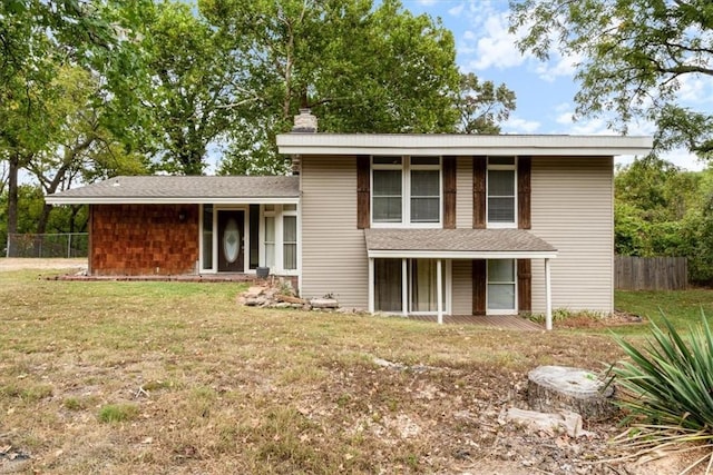 rear view of house featuring a porch, a lawn, a chimney, and fence