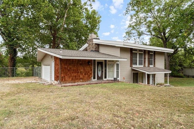 view of front facade with a chimney, a shingled roof, a front yard, fence, and a garage