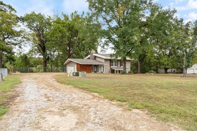 view of front of property featuring driveway, an attached garage, fence, and a front lawn